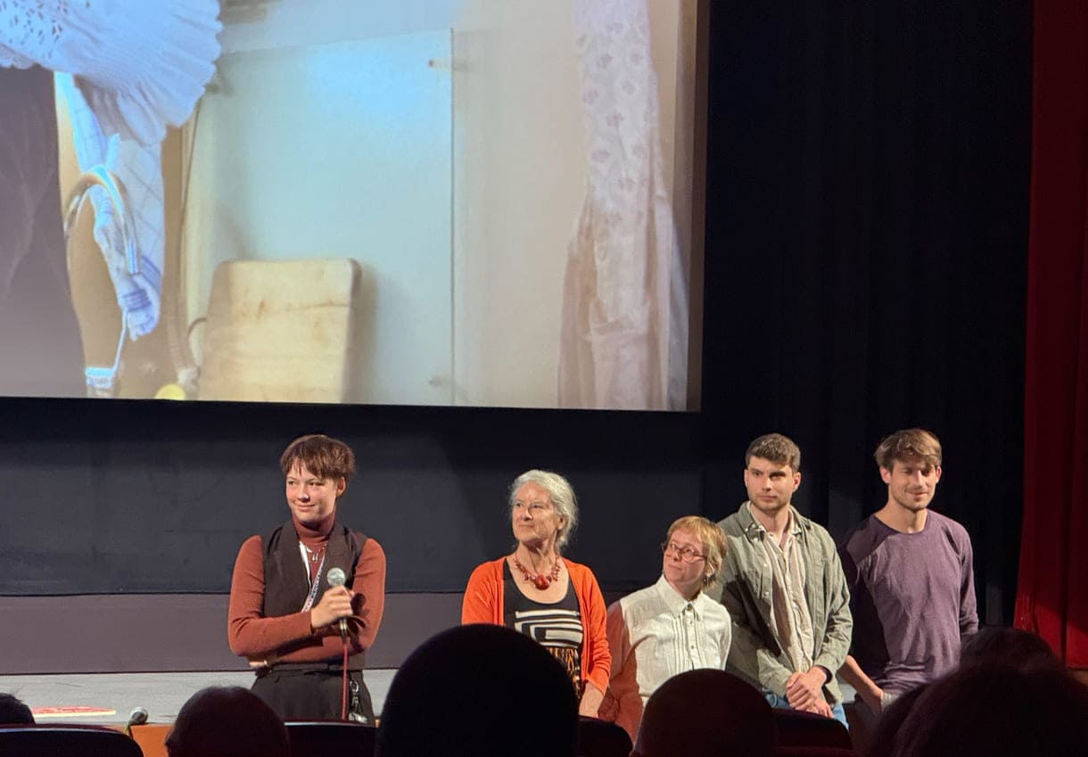 Einige aus der Crew von "Die letzte Note" beim Filmgespräch mit Expert:innen und Publikum vor der Leinwand