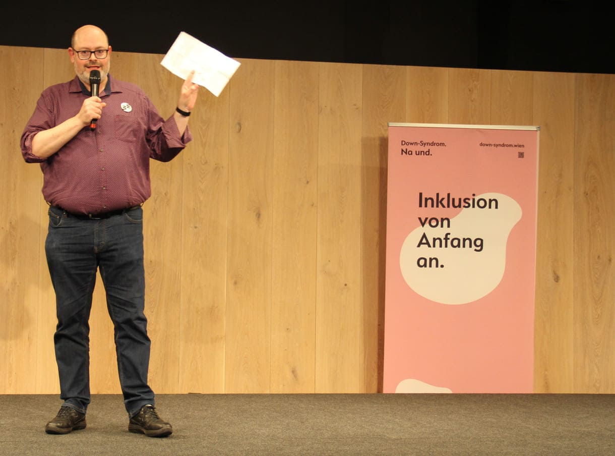 Wien-Museum-Direktor Matti Bunzl und das plakat "Down-Syndro. Na und. Inklusion von Anfang an"