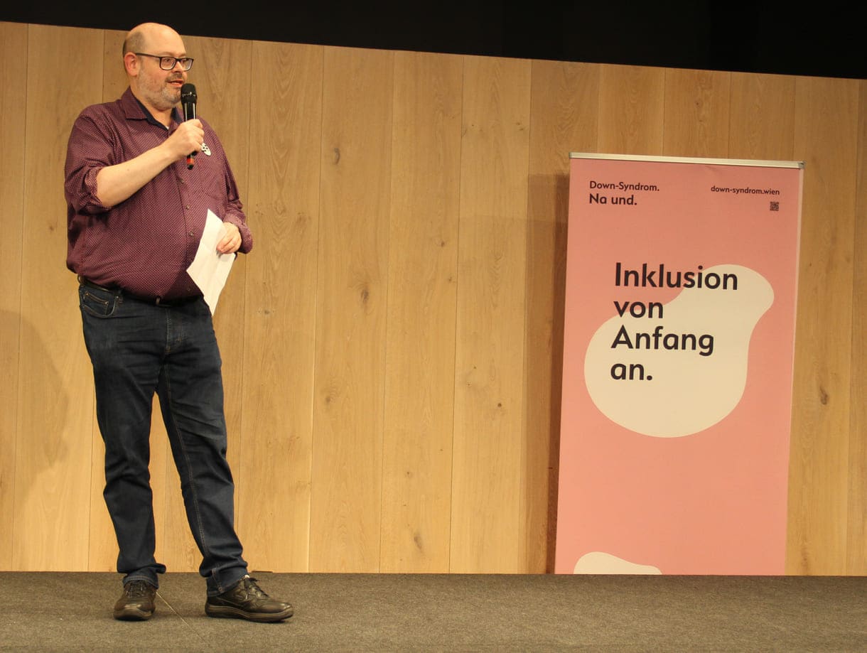 Wien-Museum-Direktor Matti Bunzl und das plakat "Down-Syndro. Na und. Inklusion von Anfang an"