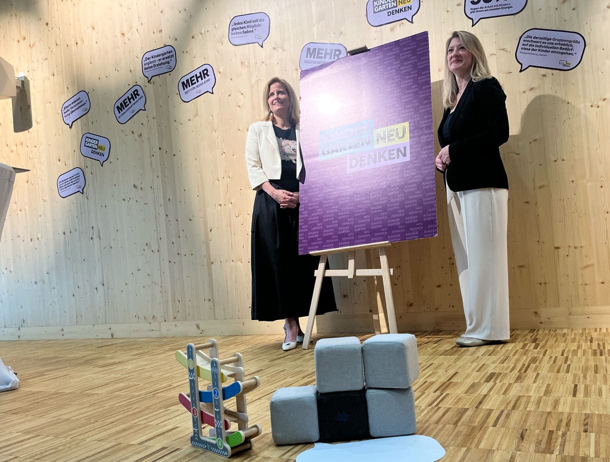 Gemeinderätin Astrid Pany (SPÖ) und Vizebürgermeisterin Bettina Emmerling (NEOS) neben dem Plakat 