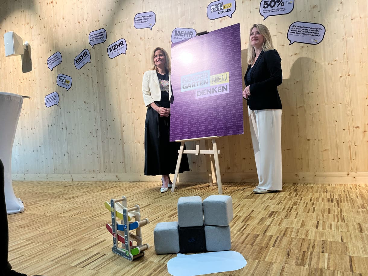 Gemeinderätin Astrid Pany (SPÖ) und Vizebürgermeisterin Bettina Emmerling (NEOS) neben dem Plakat 