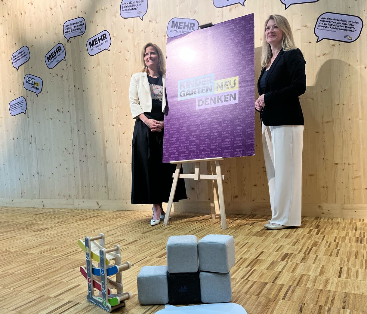 Gemeinderätin Astrid Pany (SPÖ) und Vizebürgermeisterin Bettina Emmerling (NEOS) neben dem Plakat 