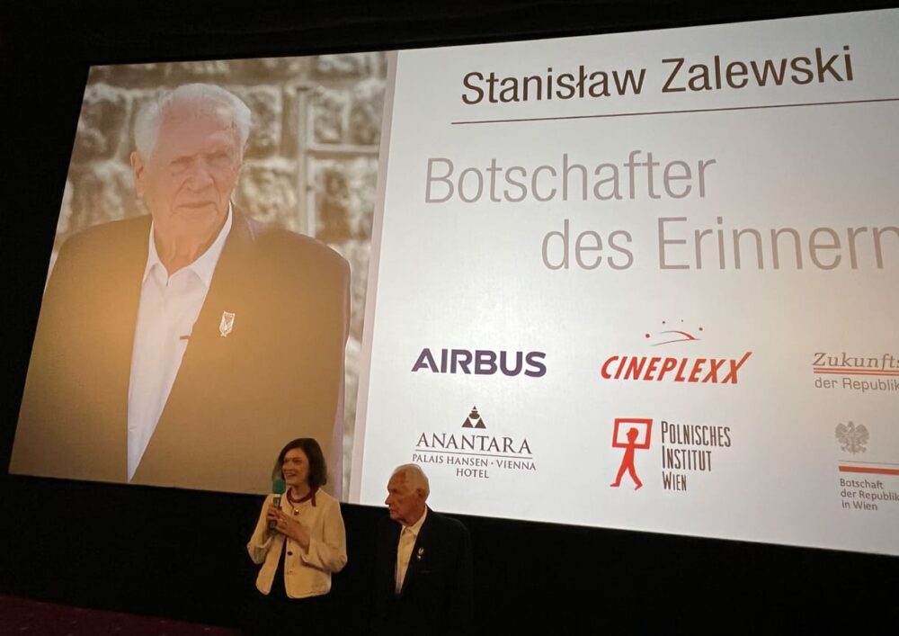 Magdalena Żelasko und Stanisław Zalewski im Kinosaal - im Hintergrund ein Bild aus dem Film sowie die Sponsor:innen