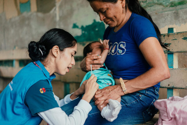Krankenschwester Bridgith Freire (Ecuador) hat Aynara Alvarado geimpft, während ihre Mutter sie hält.