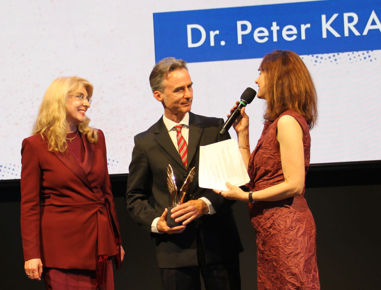 Ehren-merkur-preisträger Peter Krauskopf mit seienr Laudatorin, WU-Professorin Bettina Fuhrmann und Moderatorin Daniela Zeller