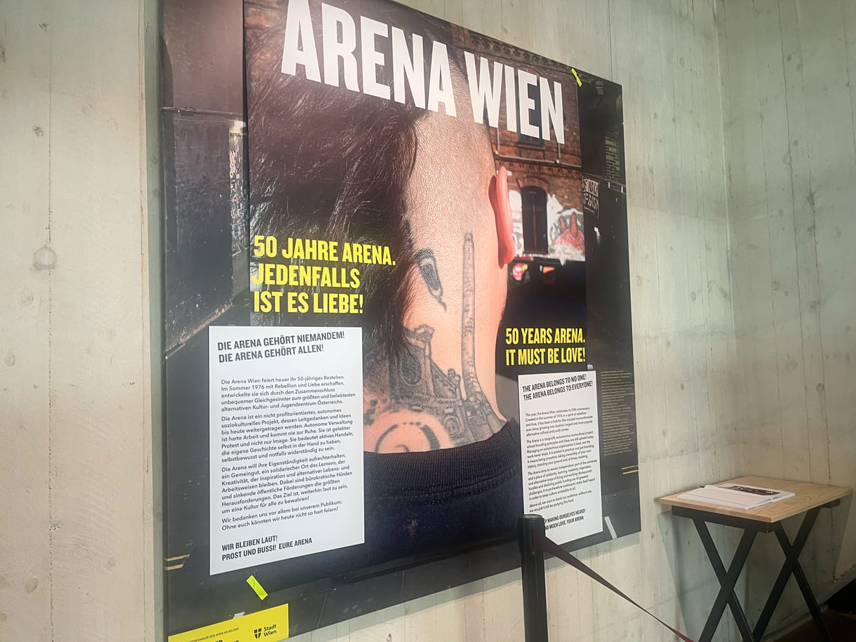 Plakat im Eingangsbereich zur Community-Gallery mit der aktuellen Arena-Ausstellung