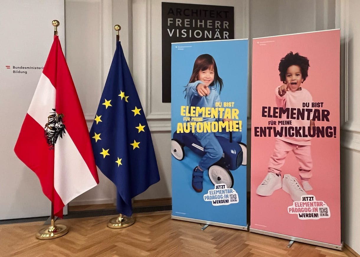 Starke Kinder werben um (ihre) Elementarpädagog:innen, links im Bild: Österreich- und EU-Fahne