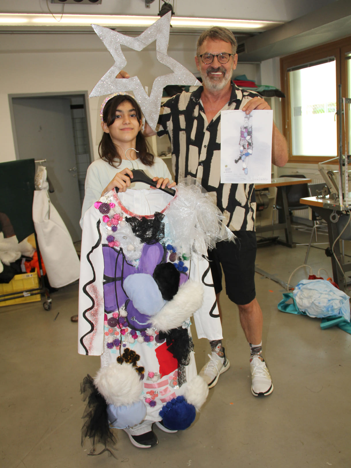 Elida Çulhacı mit dem Kleid, das ihrem Entwurf entspricht und Leo Oswald, Erfinder und künstlerischer Leiter von Kids in Fashion