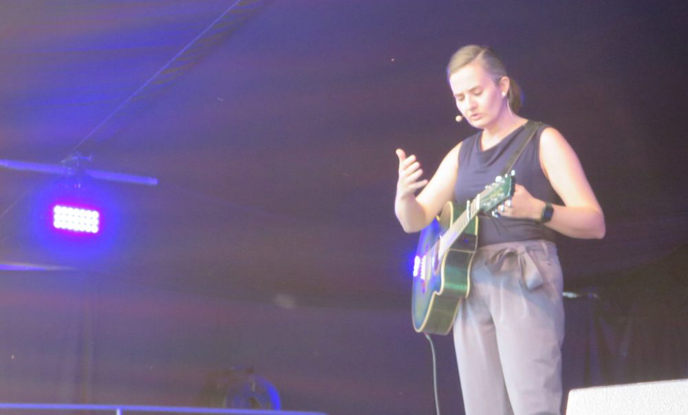 Kabarettistin Elli Bauer mit Gitarre auf der Bühne im Schwechater Felmayergarten