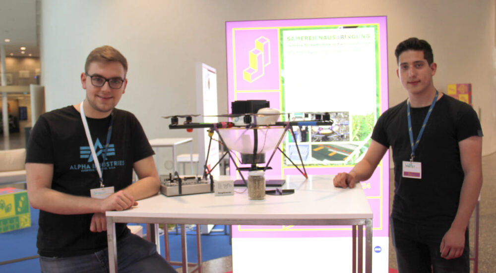 Benedikt Ortmaier und Sebastian Schäffer mit ihrer Drohne mit Behälter für Saatgut und Streu-Teller
