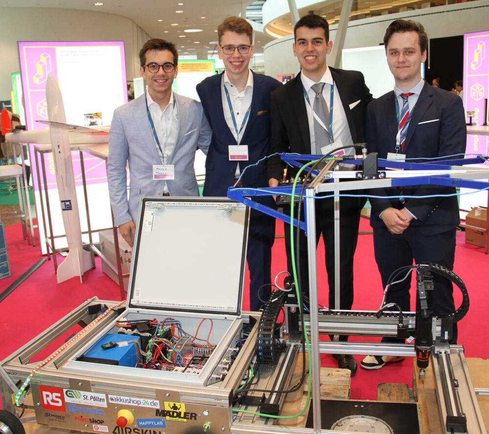 Marco Mazur, Alessandro Nentwich, Fabrizio Belisarii und Christopher Dienstl mit ihrem Schraub-Roboter für Leuchten auf Flughafen-Rollfeldern