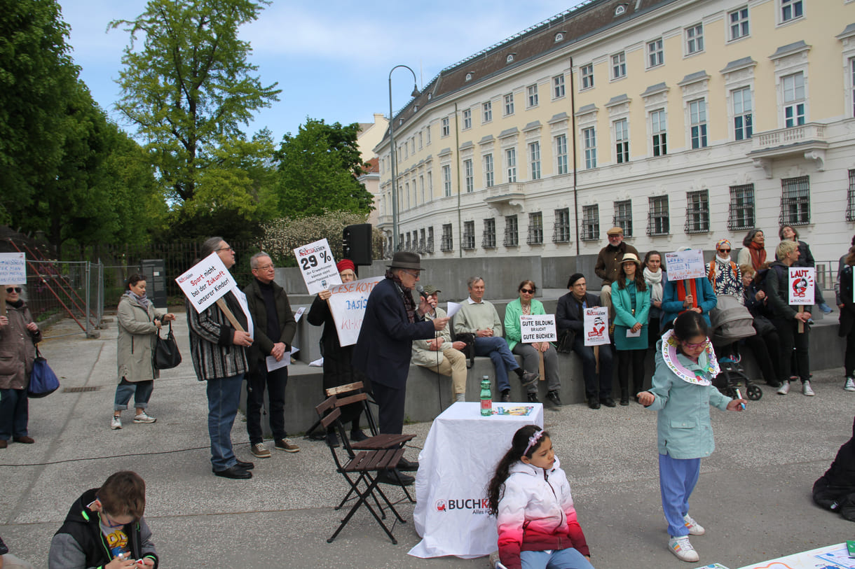Demonstrant:innen mit Sprüchen auf Kartontafeln