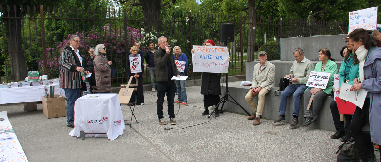 Demonstrant:innen mit Sprüchen auf Kartontafeln