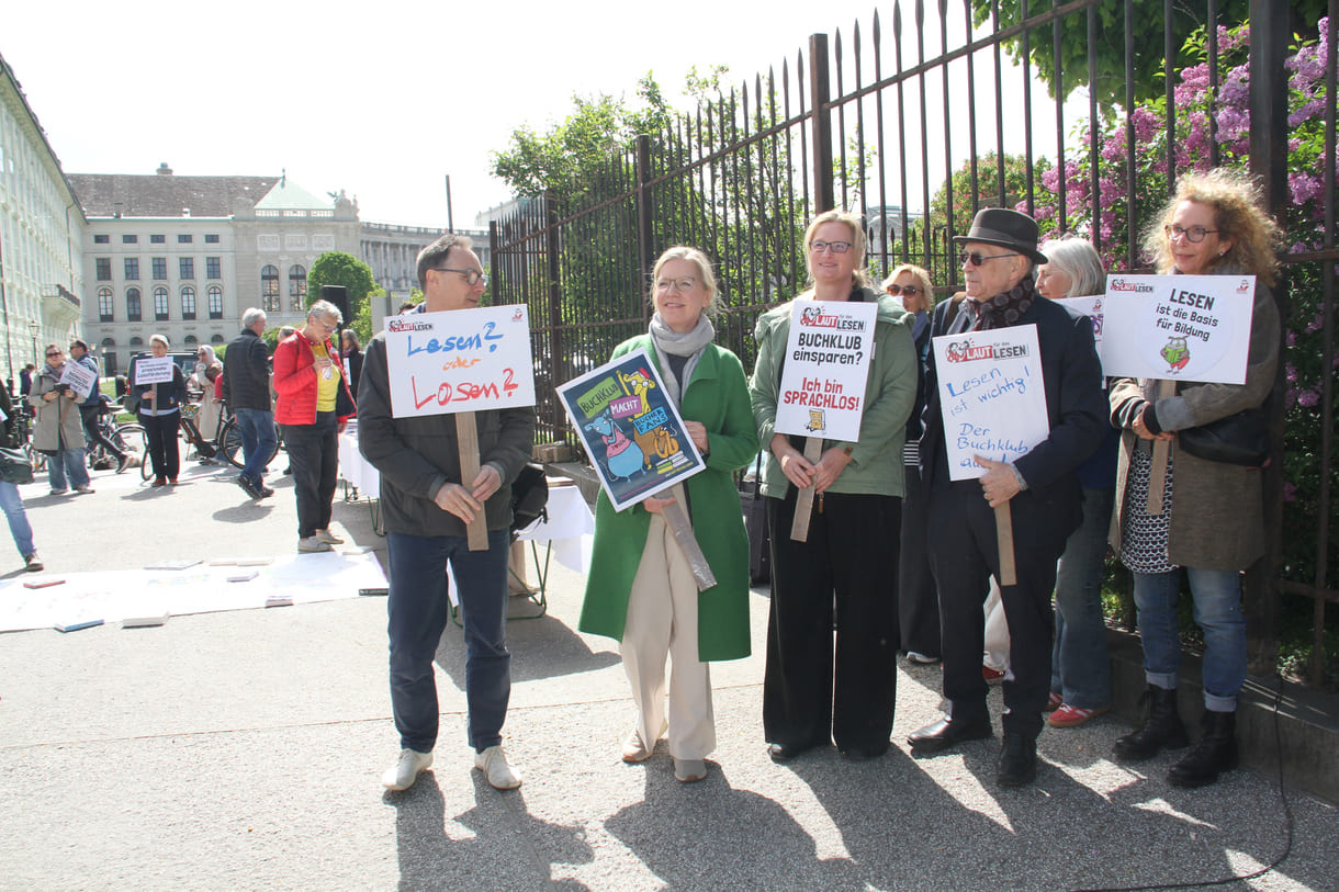 Demonstrant:innen mit Sprüchen auf Kartontafeln