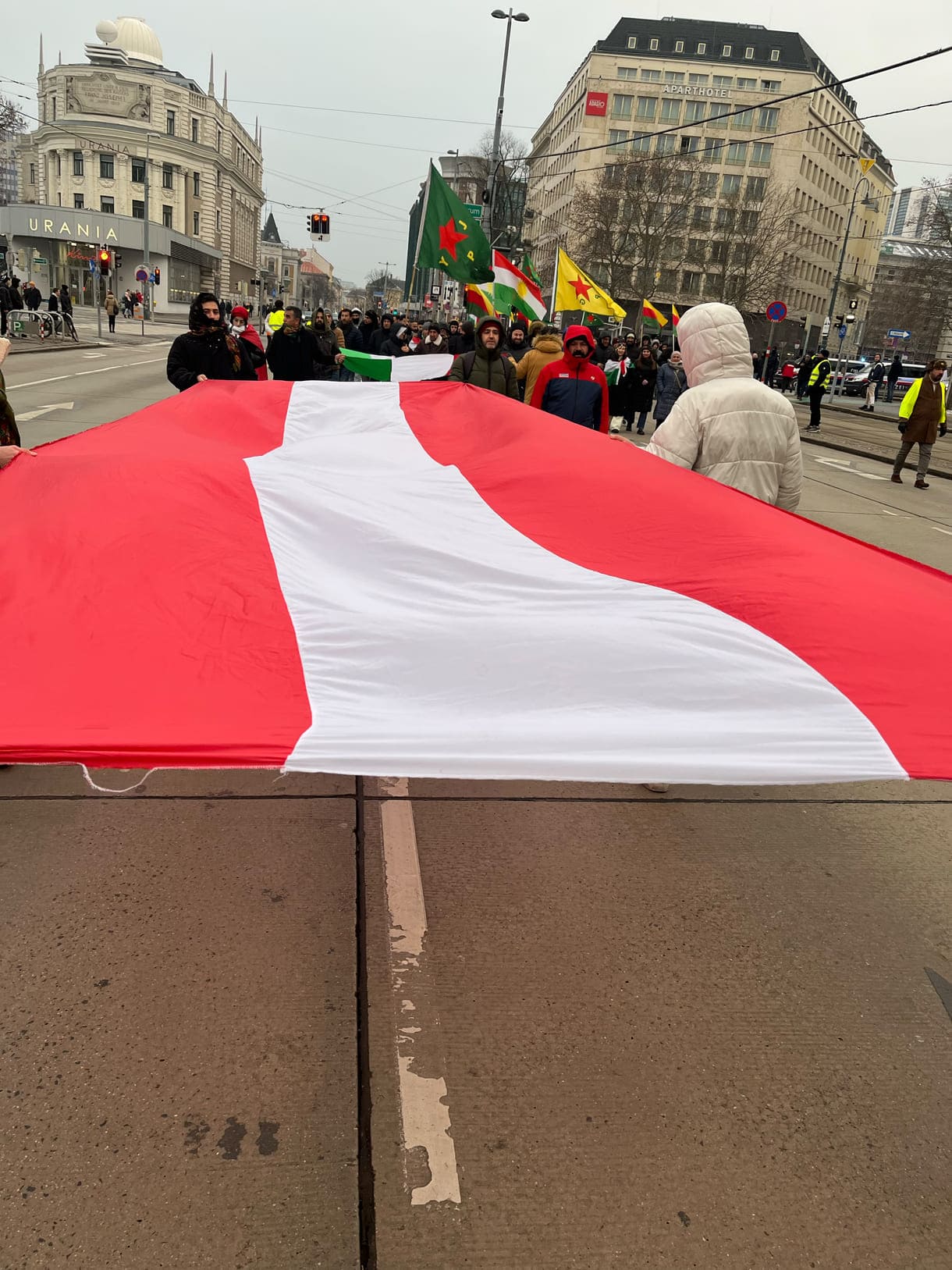 Große kurdische und österreichische Fahnen