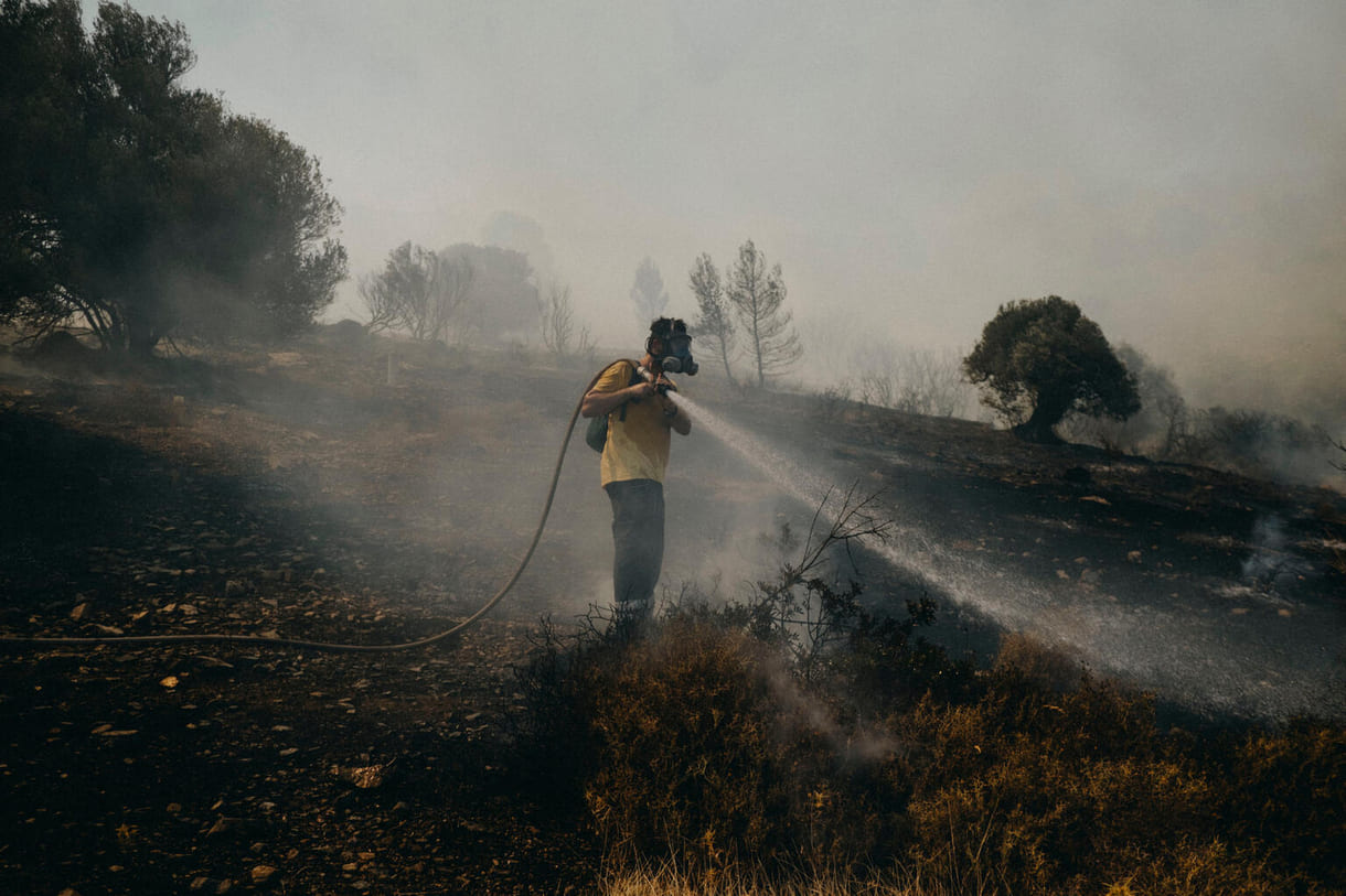 Ein freiwilliger Feuerwehrmann hilft beim Löschen eines Brandes im Stadtteil Plaka in Keratea, 40 km südöstlich von Athen, Griechenland (2021)