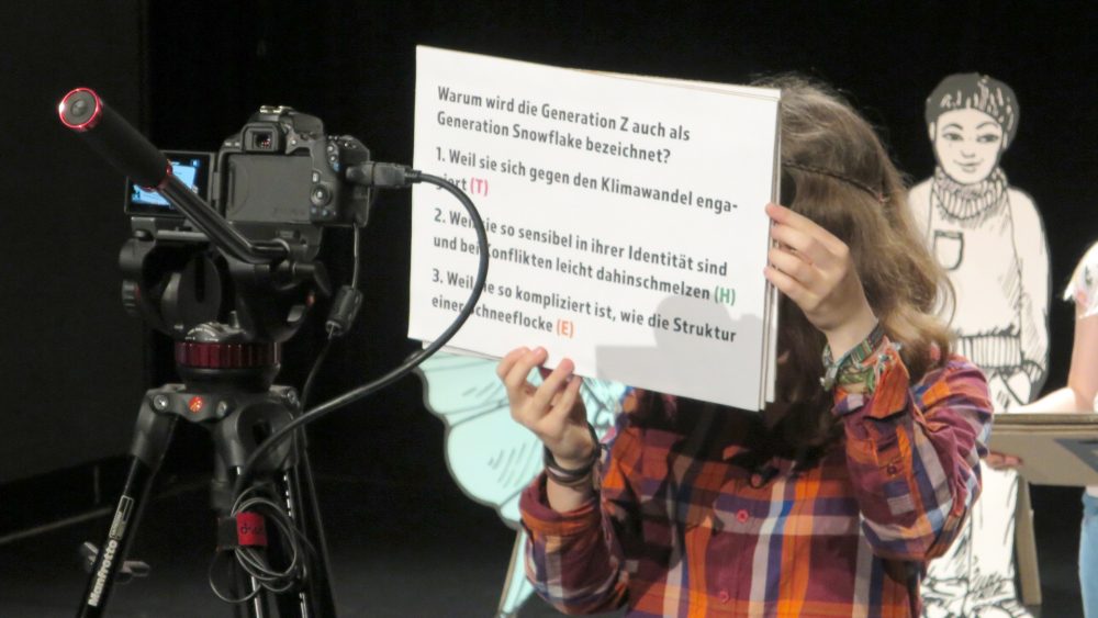 Ein Kind hält große Fragekarte in die Kamera