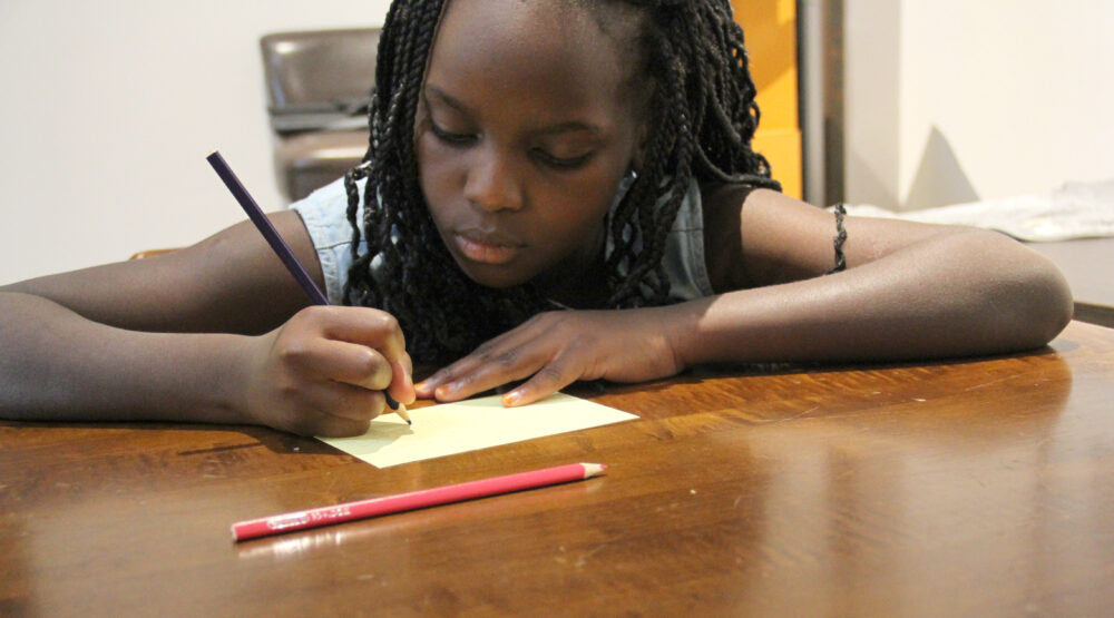 Kinder schreiben auf Zettel