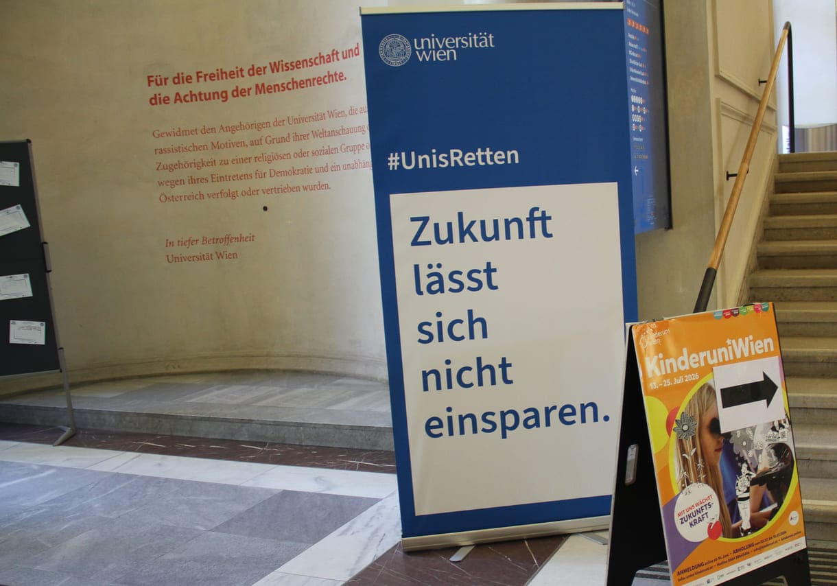 Für Freiheit der Wissenschaft und Achtung der Menschenrchte - Aufschrift an einer der Aula-Wände und davor ein Banner von #UnisRetten: Zukunft lässt sich nicht einsparen