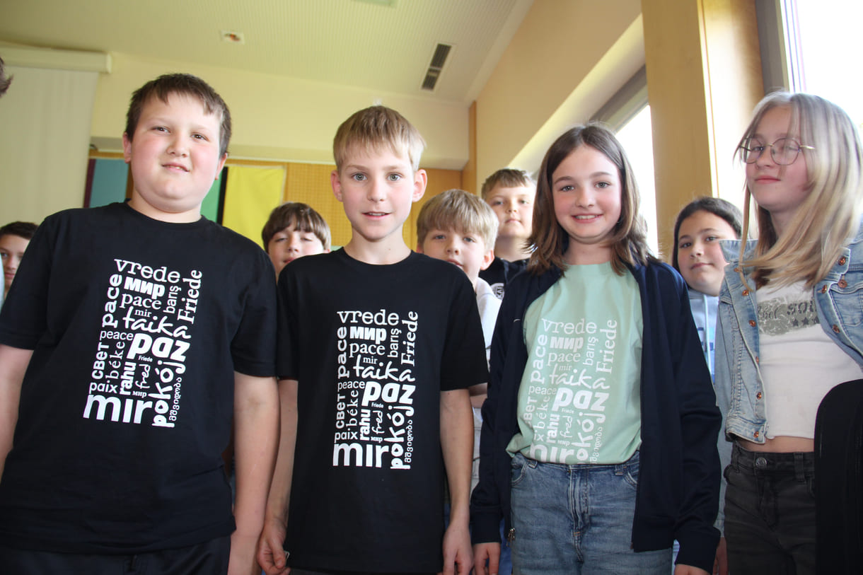 Schüler:innen mit den Schul-T-Shirts: Frieden in vielen Sprachen
