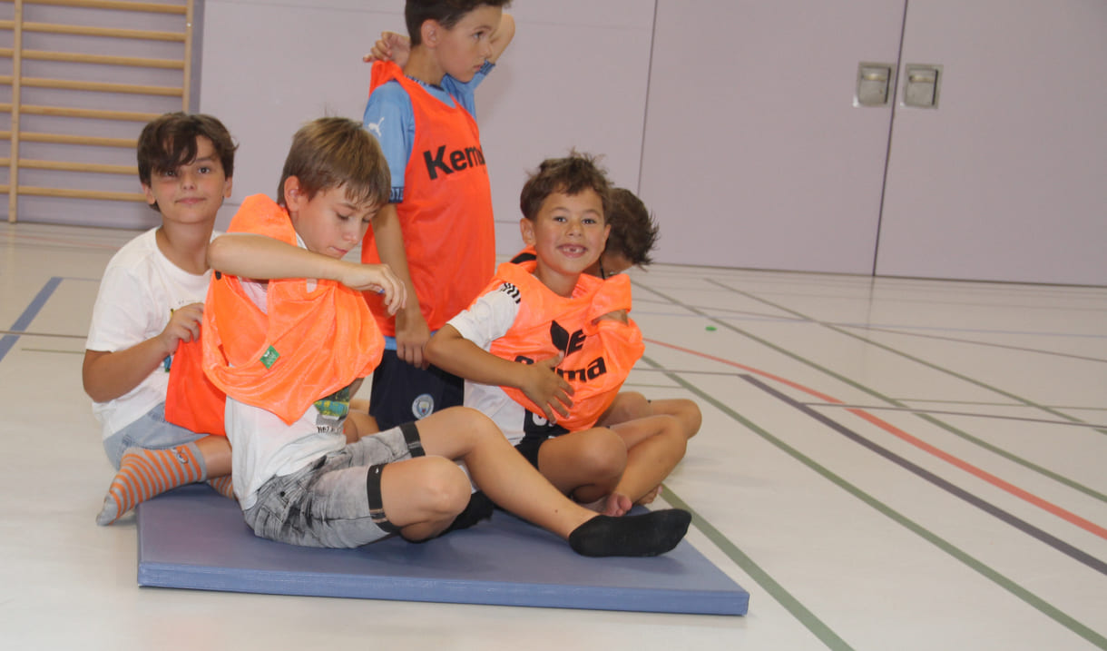 Eines der Frisbee-Match-Teams zieht sich orange-farbene Westen an