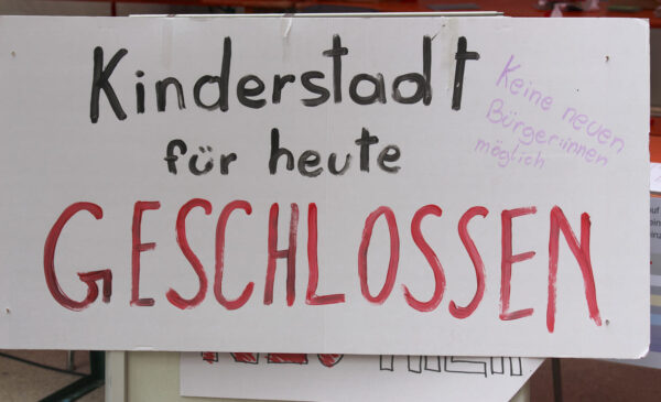 Handgeschriebenes Plakat auf dem steht, dass die Kinderstadt - vorübergehend - geschlossen werden musste