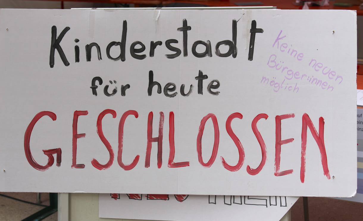 Handgeschriebenes Plakat auf dem steht, dass die Kinderstadt - vorübergehend - geschlossen werden musste