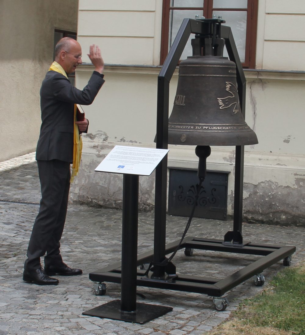 Dompfarrer Toni Faber weiht die Friedensglocke im Hof des Bezirksmuseums Brigittenau