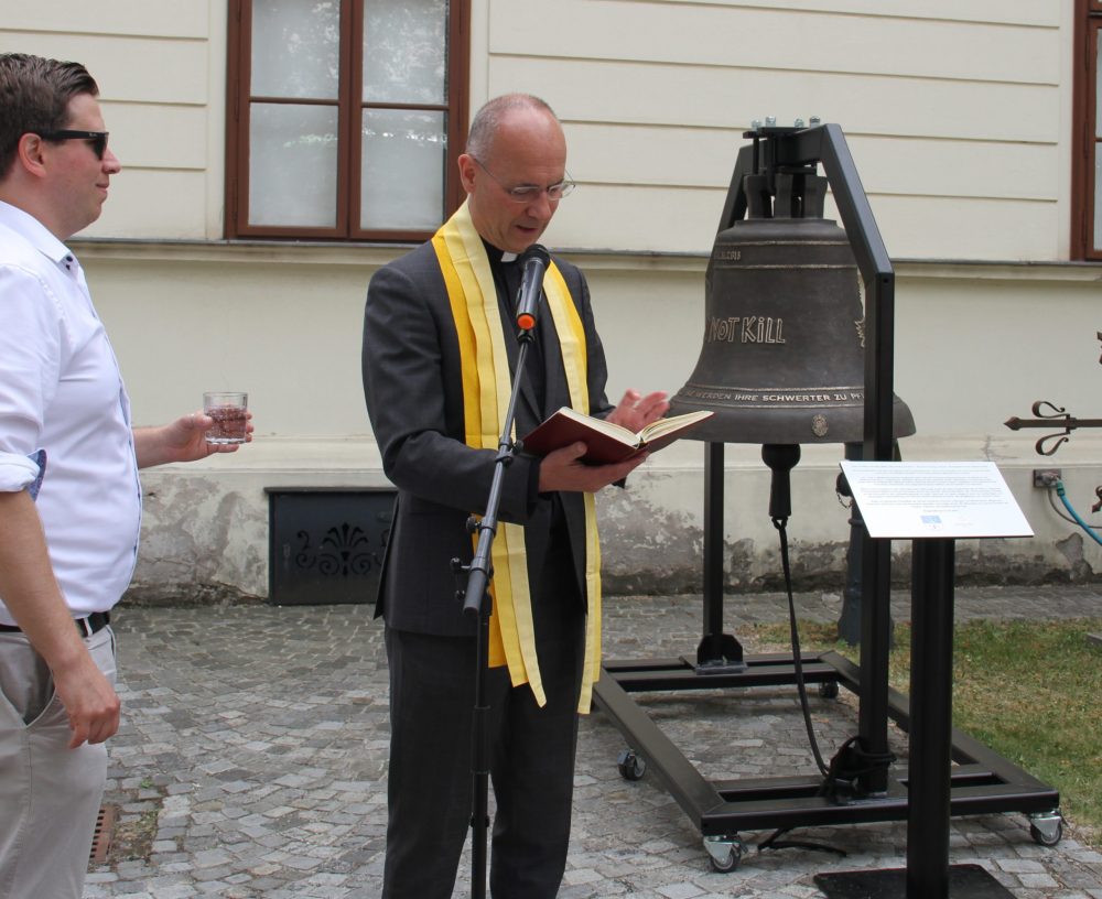 Dompfarrer Toni Faber weiht die Friedensglocke im Hof des Bezirksmuseums Brigittenau