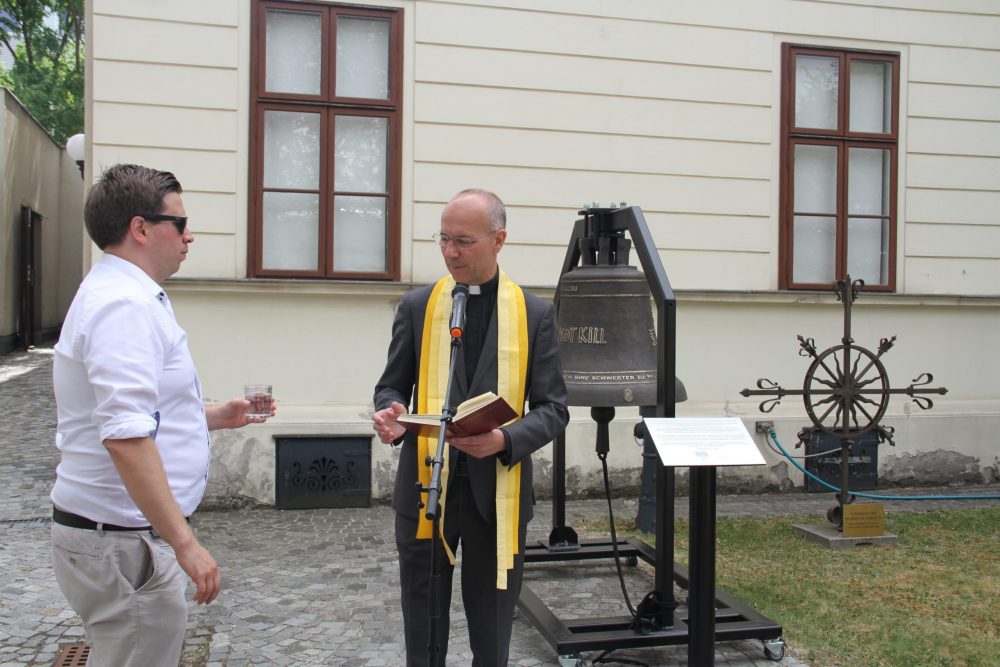 Dompfarrer Toni Faber weiht die Friedensglocke im Hof des Bezirksmuseums Brigittenau