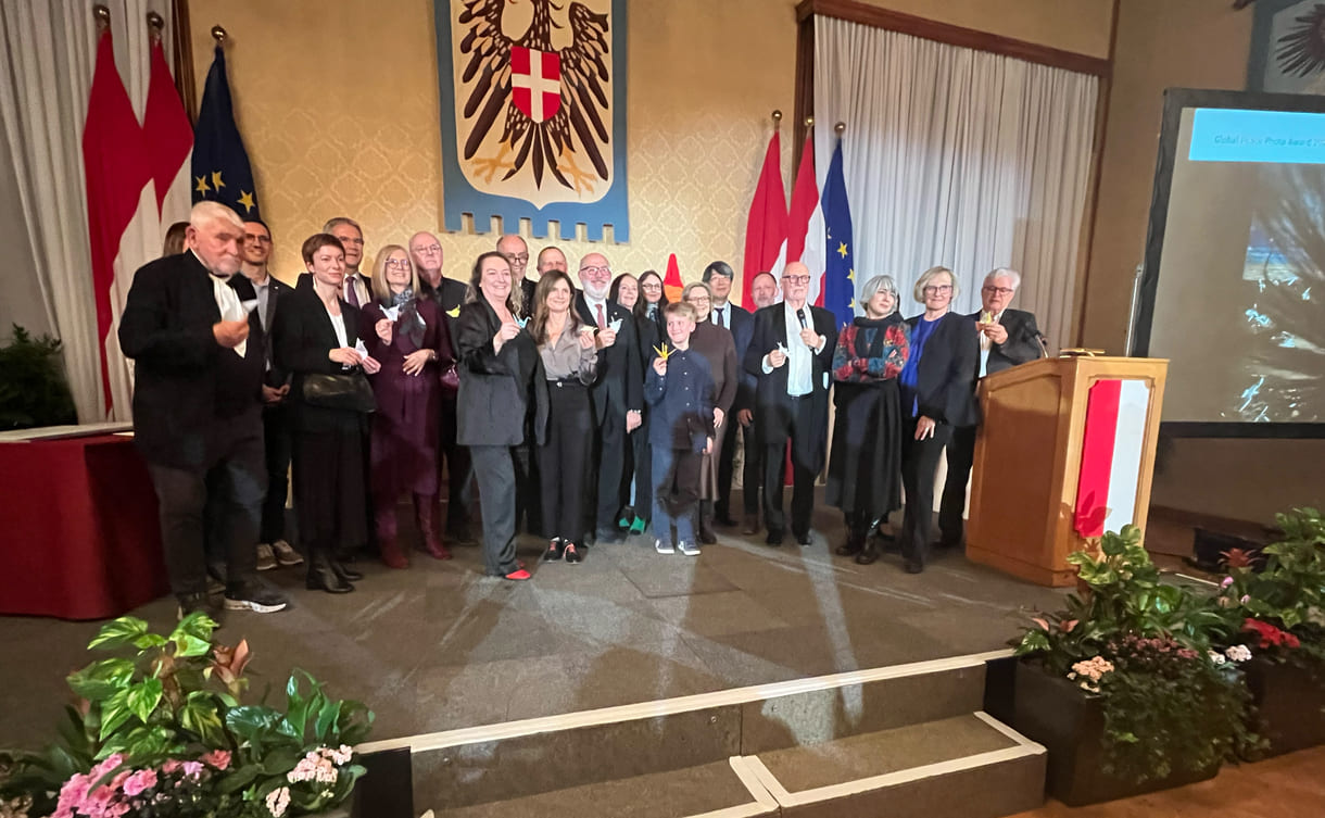 Großgruppenfot der anwesenden Gewinner:innen, Laudator:innen, Sponsor:innen... - mit gefalteten Papierkranichen