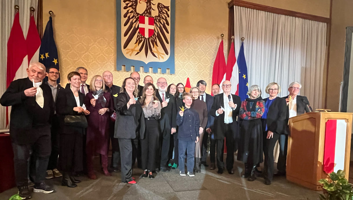 Großgruppenfot der anwesenden Gewinner:innen, Laudator:innen, Sponsor:innen... - mit gefalteten Papierkranichen