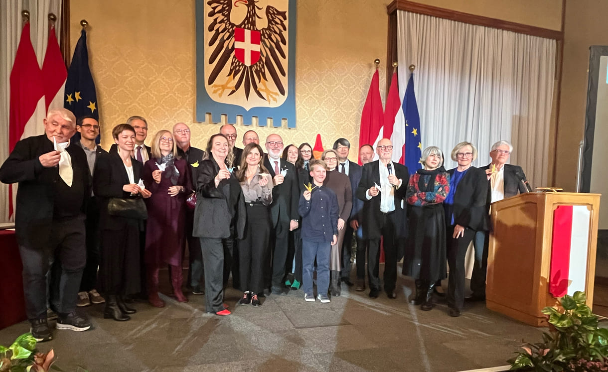 Großgruppenfot der anwesenden Gewinner:innen, Laudator:innen, Sponsor:innen... - mit gefalteten Papierkranichen