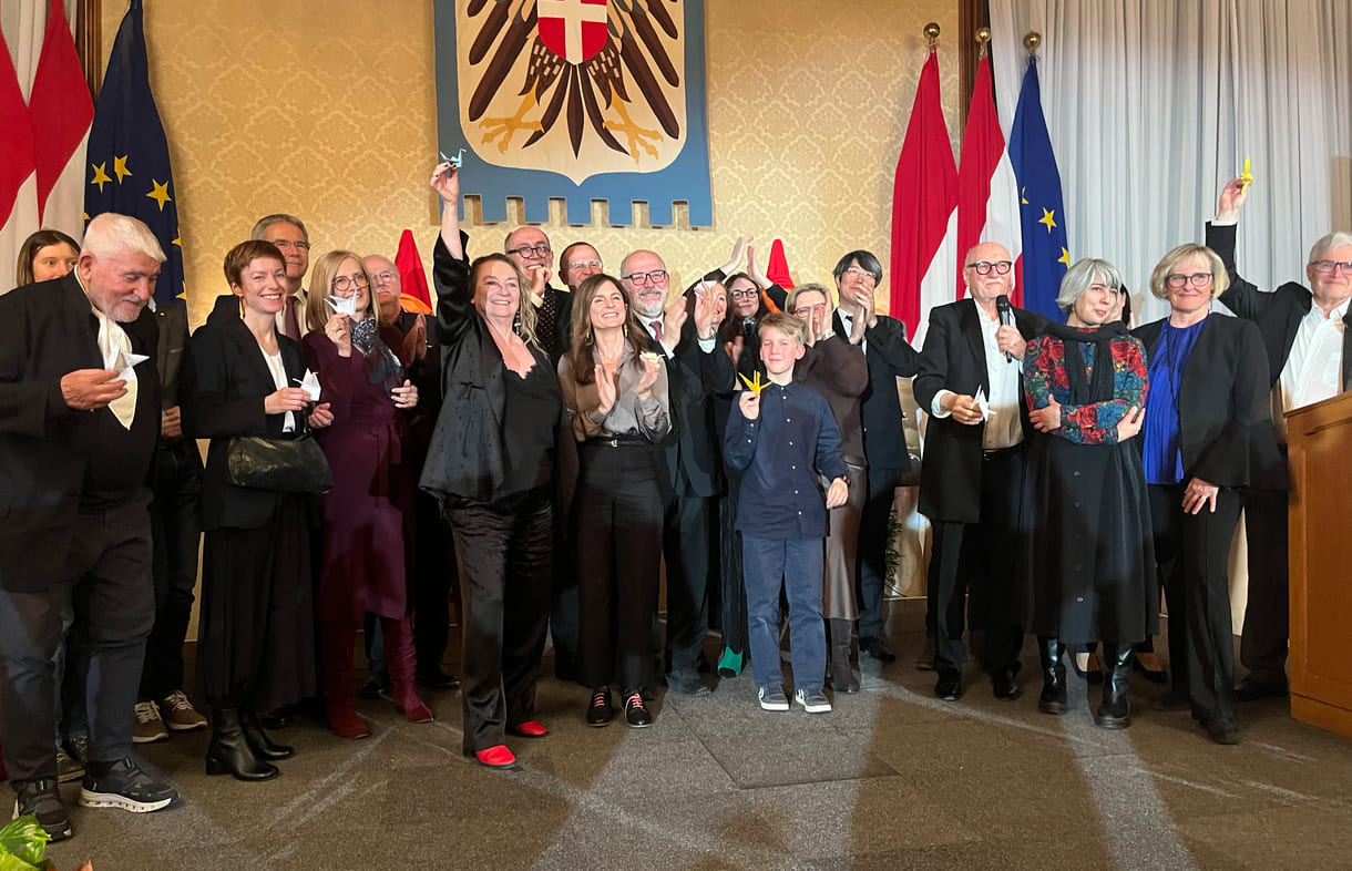 Großgruppenfot der anwesenden Gewinner:innen, Laudator:innen, Sponsor:innen... - mit gefalteten Papierkranichen