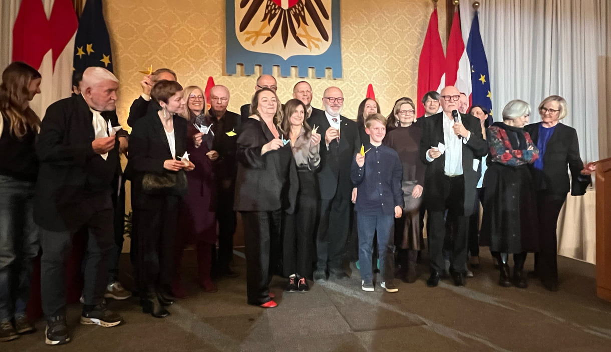 Großgruppenfot der anwesenden Gewinner:innen, Laudator:innen, Sponsor:innen... - mit gefalteten Papierkranichen