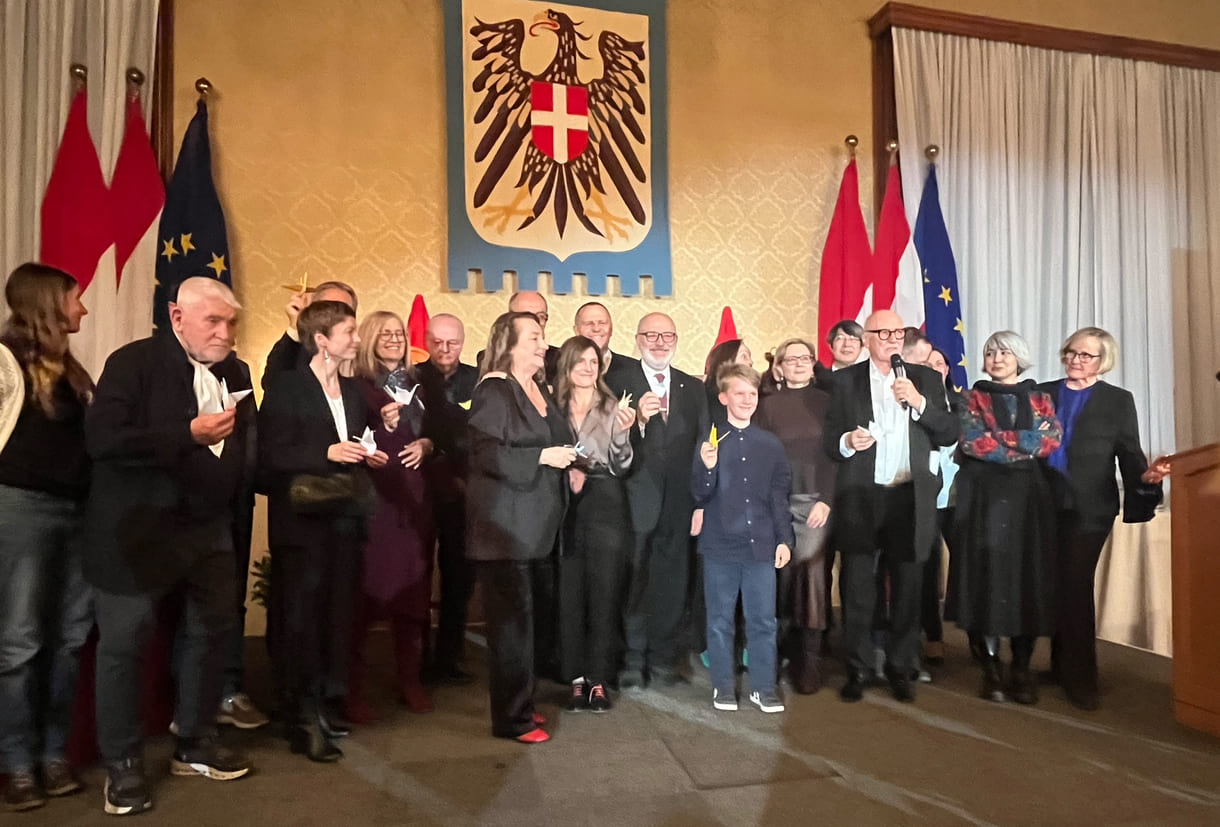 Großgruppenfot der anwesenden Gewinner:innen, Laudator:innen, Sponsor:innen... - mit gefalteten Papierkranichen