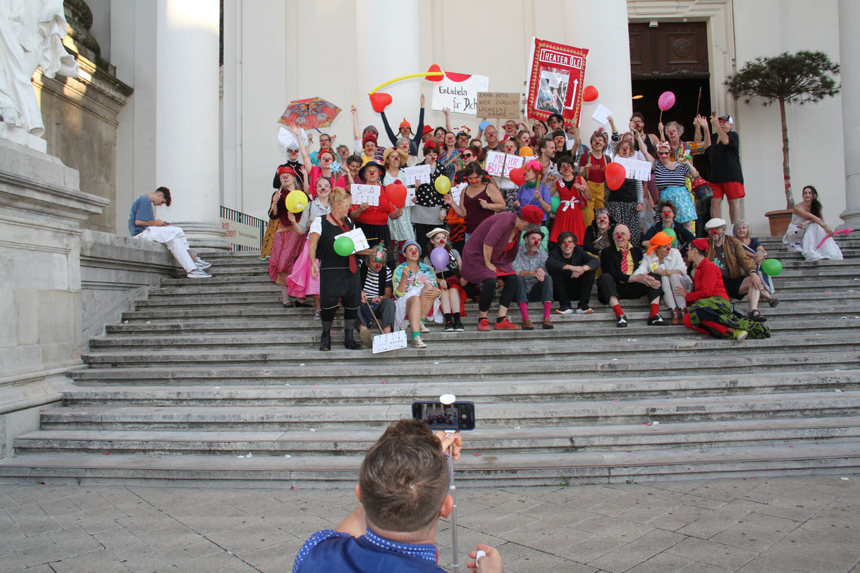 Abschließendes Gruppenfoto aller Clown:innen auf den Stufen hinauf zur Karlskirche (Wien)