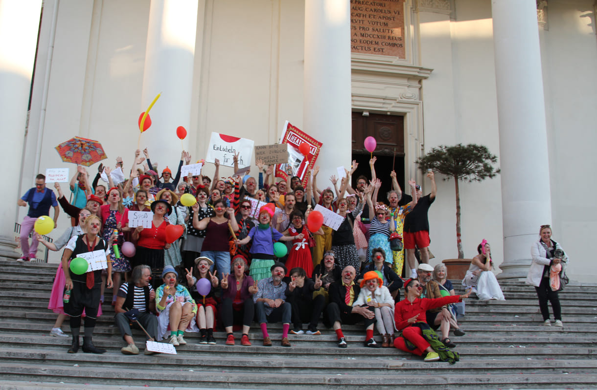 Abschließendes Gruppenfoto aller Clown:innen auf den Stufen hinauf zur Karlskirche (Wien)