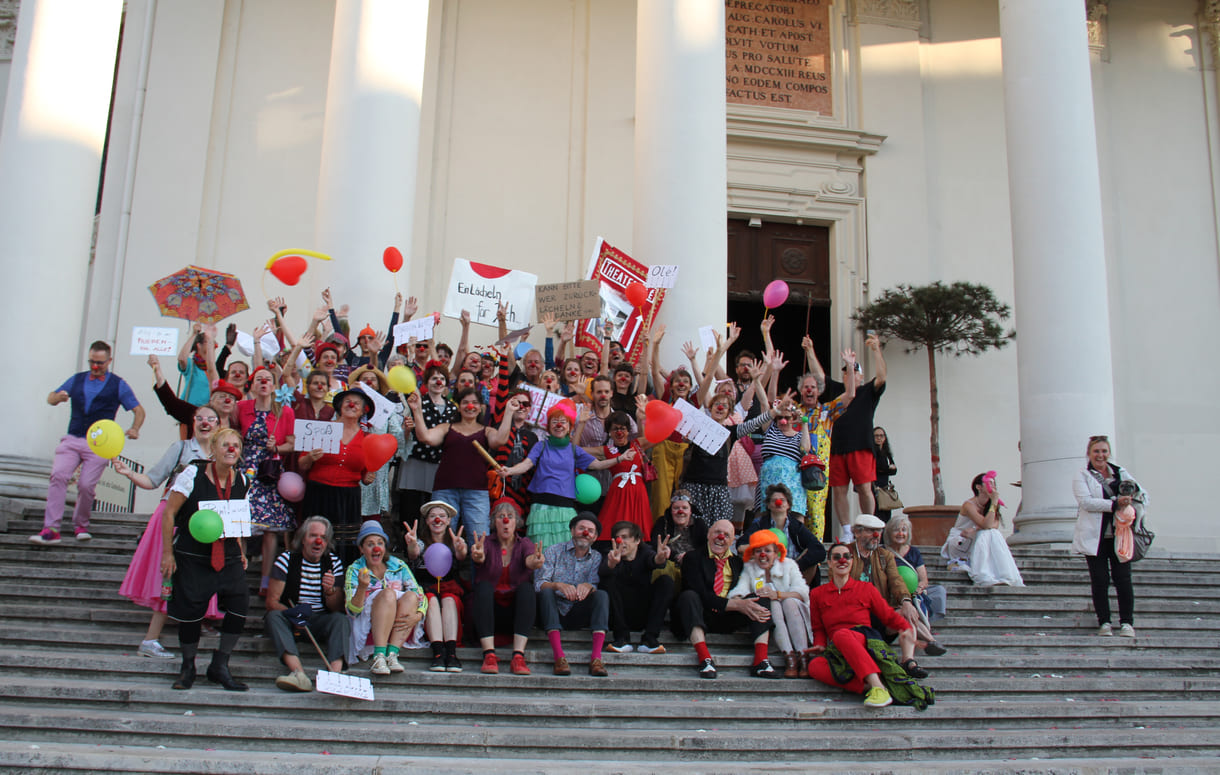 Abschließendes Gruppenfoto aller Clown:innen auf den Stufen hinauf zur Karlskirche (Wien)