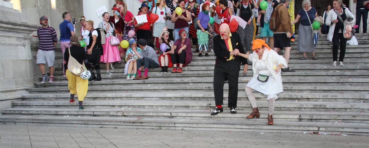 Abschließendes Gruppenfoto aller Clown:innen auf den Stufen hinauf zur Karlskirche (Wien)