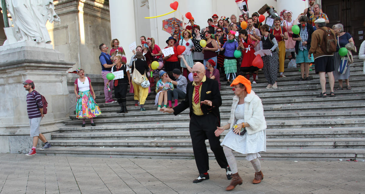 Abschließendes Gruppenfoto aller Clown:innen auf den Stufen hinauf zur Karlskirche (Wien)