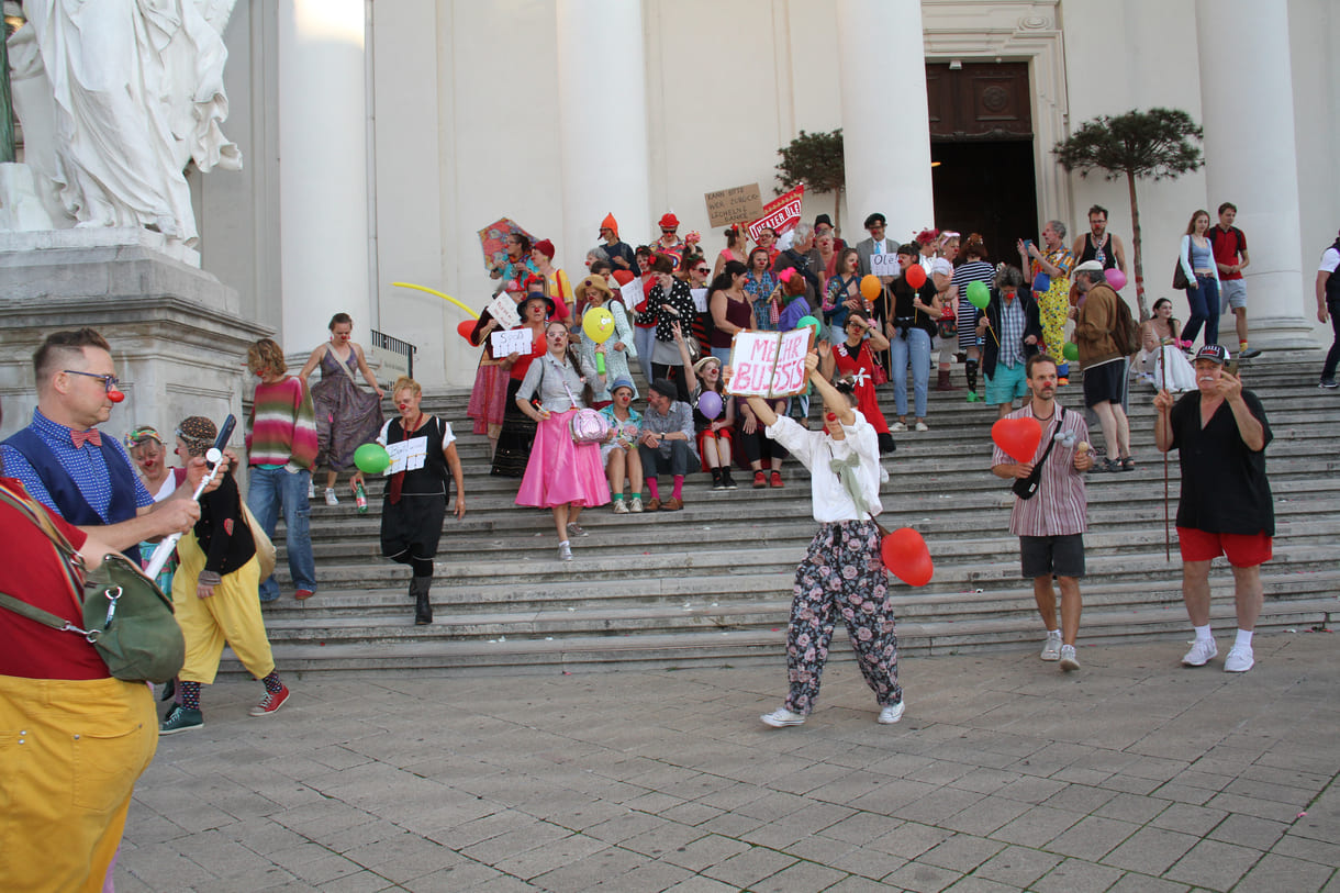 Abschließendes Gruppenfoto aller Clown:innen auf den Stufen hinauf zur Karlskirche (Wien)