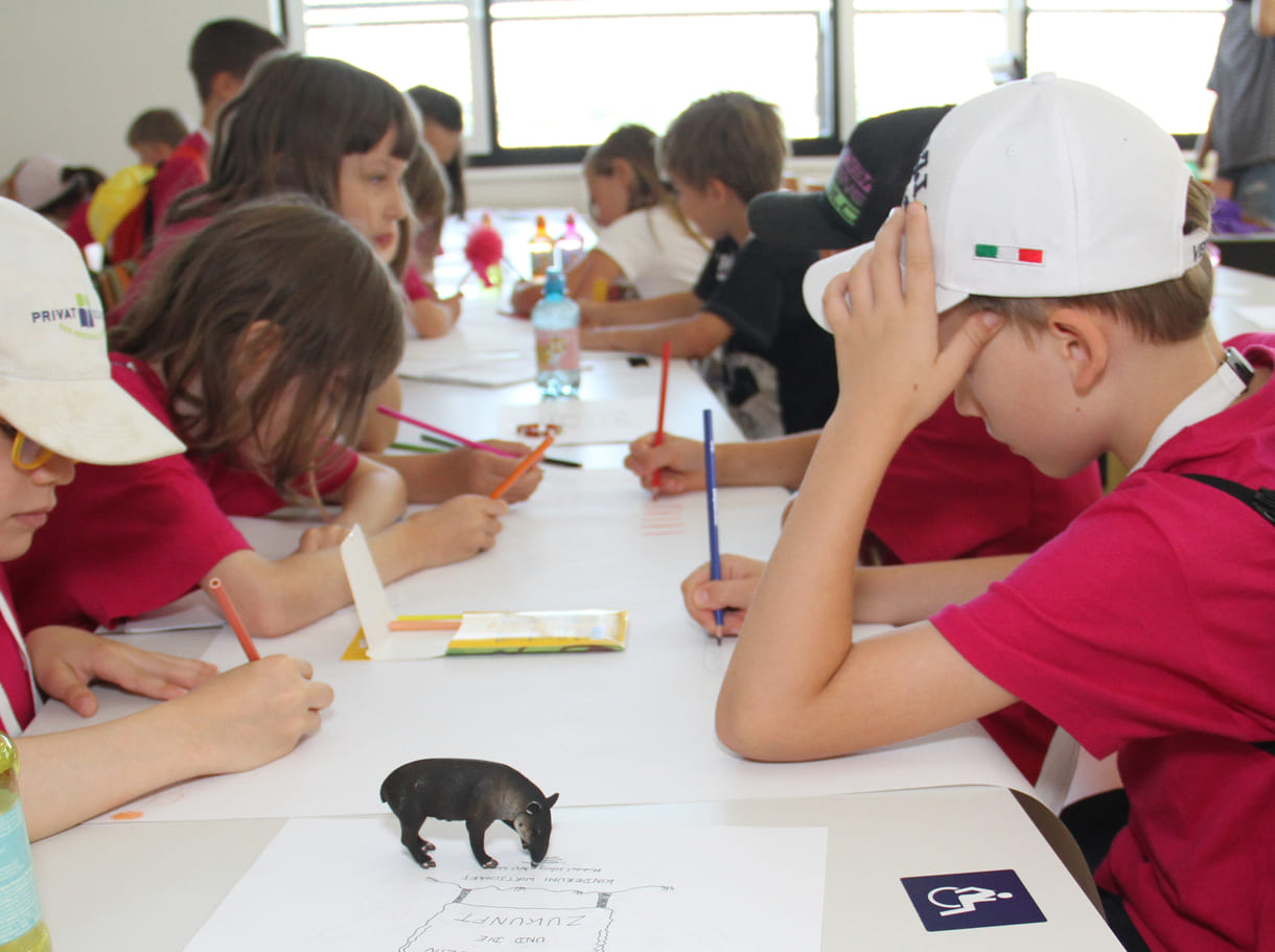 Meist in Gruppen zeichnen und schreiben Kinderuni-Studierende Ideen für die Weiterentwicklung von Tapir Fridolins Kaufmannsladen