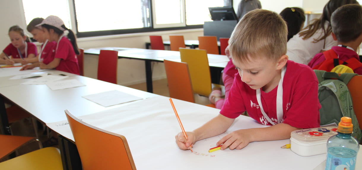 Meist in Gruppen zeichnen und schreiben Kinderuni-Studierende Ideen für die Weiterentwicklung von Tapir Fridolins Kaufmannsladen