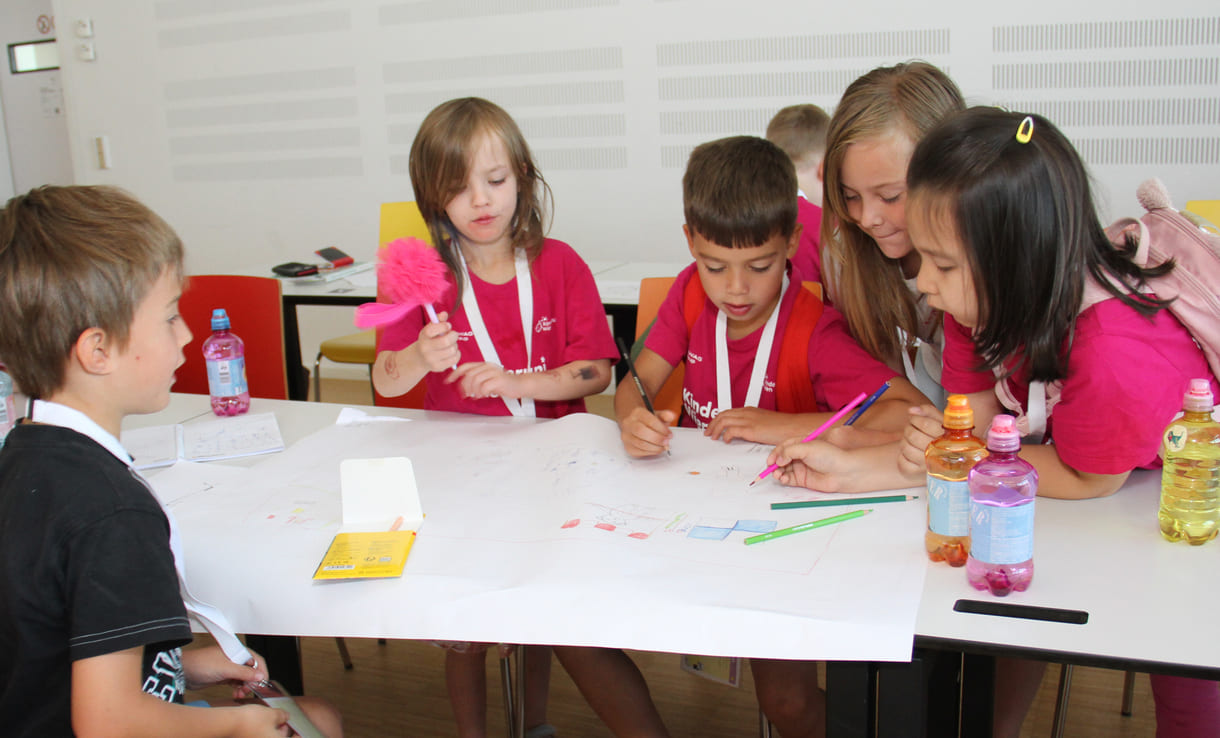 Meist in Gruppen zeichnen und schreiben Kinderuni-Studierende Ideen für die Weiterentwicklung von Tapir Fridolins Kaufmannsladen