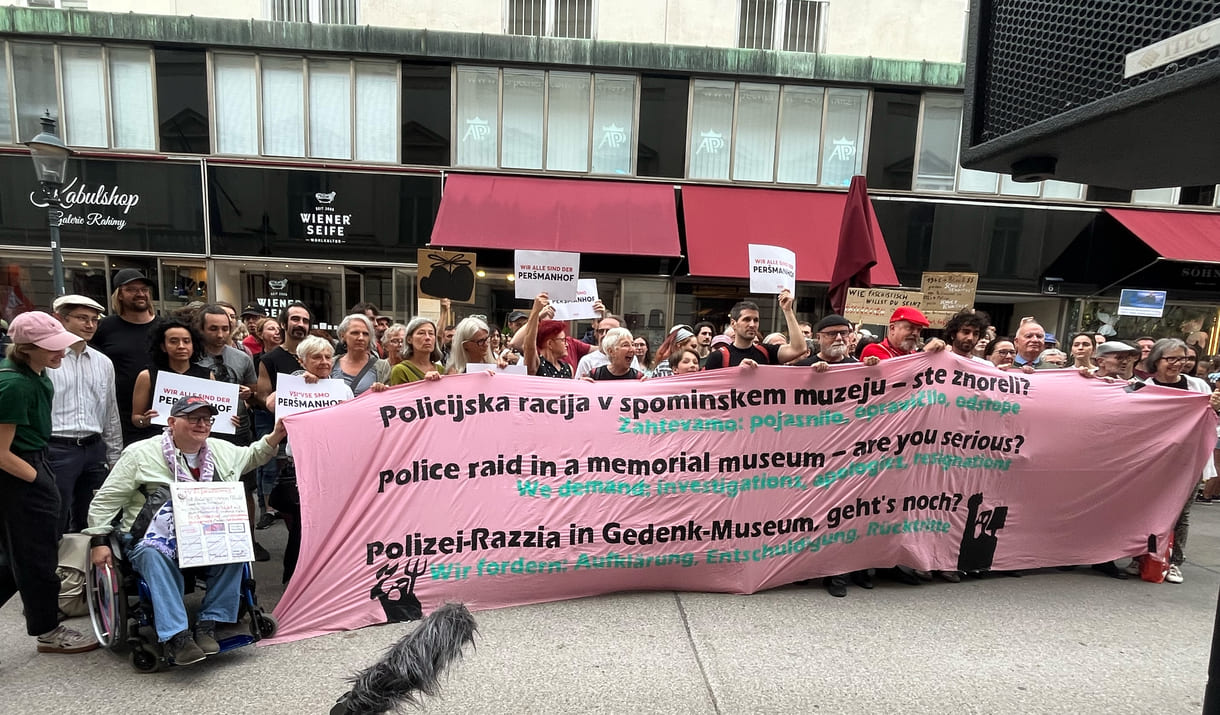 Gruppenfoto einiger Teilnehmer:innen mit einem dreisprachigen Transparent
