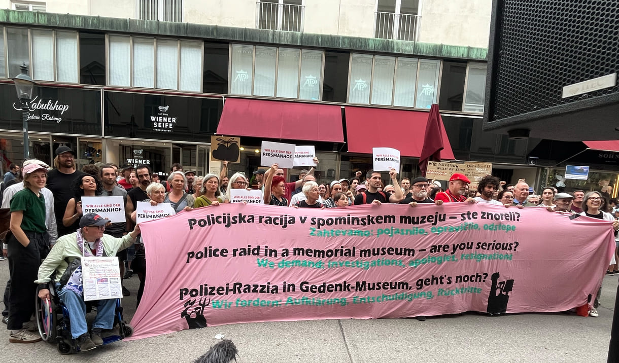 Gruppenfoto einiger Teilnehmer:innen mit einem dreisprachigen Transparent