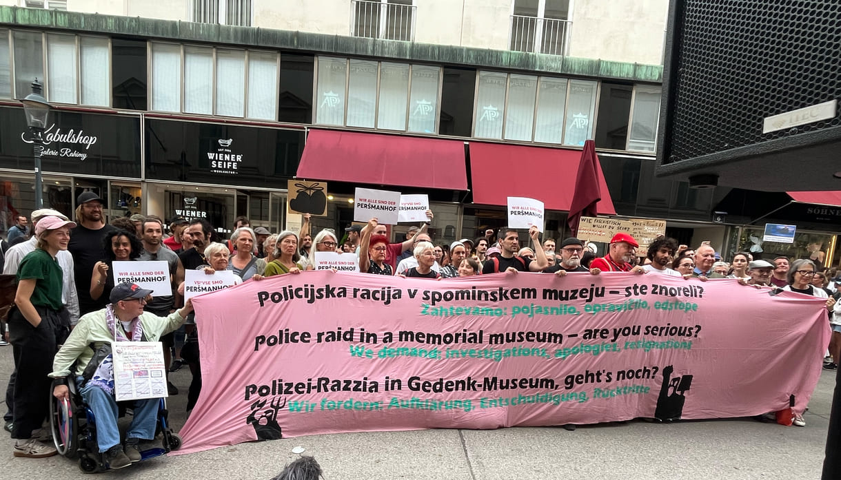 Gruppenfoto einiger Teilnehmer:innen mit einem dreisprachigen Transparent