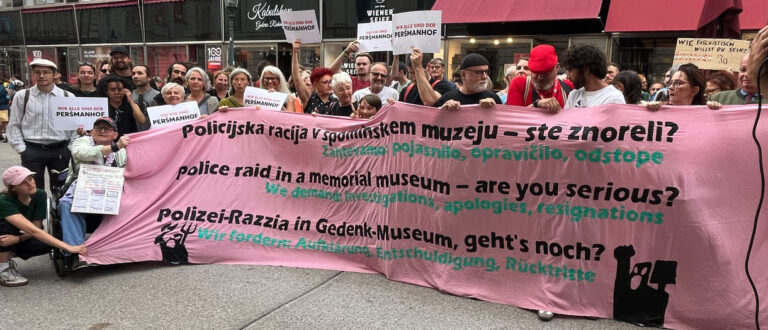 Gruppenfoto einiger Teilnehmer:innen mit einem dreisprachigen Transparent