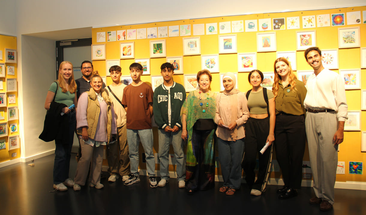 Gruppenfoto von Jugendlichen, die gemalt hatten mit breuenden Pädagoginnen, Organisator:innen und der Initiatorin von 